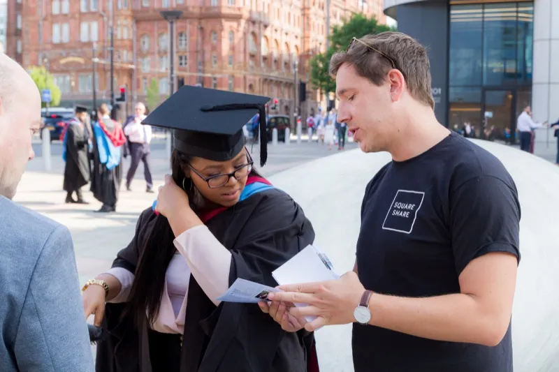 SquareShare team member handing a print to a graduate